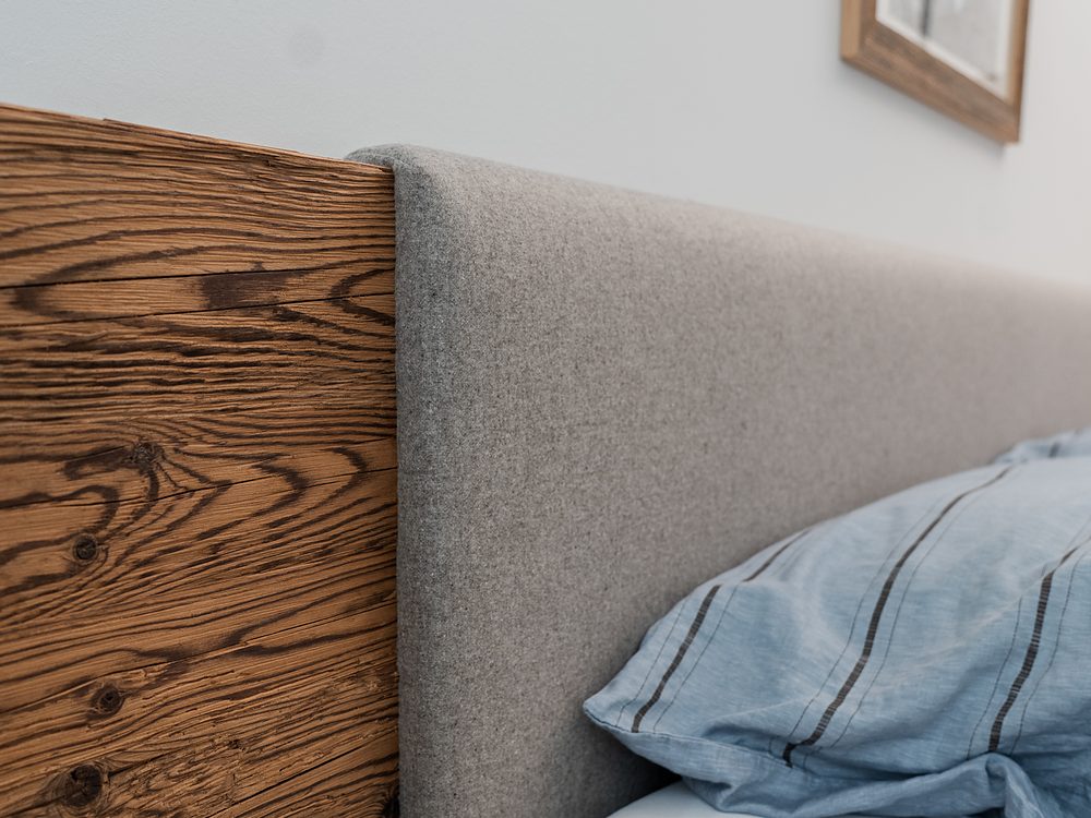 Bett mit Altholz-Wandverkleidung